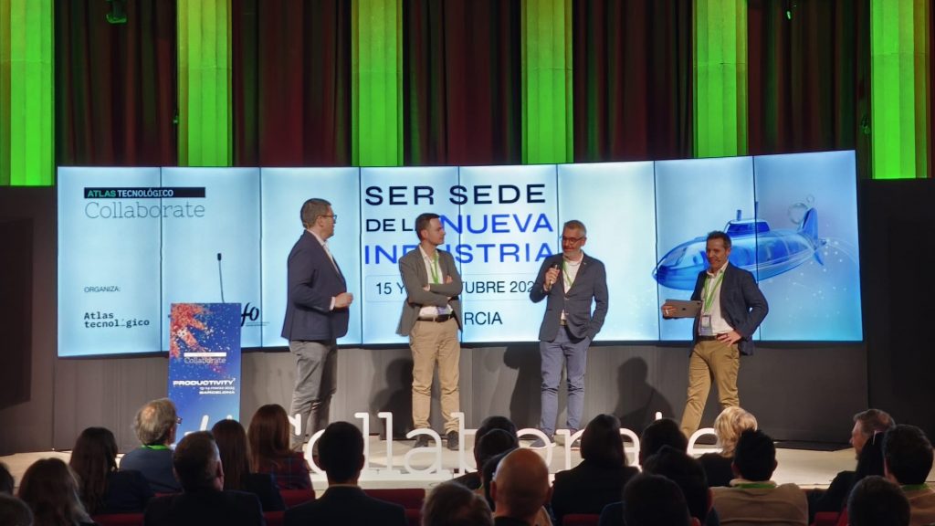 Antes de la proyección del vídeo, Pablo Oliete (CE0 de Atlas Tecnológico) invitó a Bernardino Romera y Ángel Alba (CEO de Innolandia) a subir al escenario para que, como murcianos, invitaran a los asistentes a viajar a su Región para el Collaborate